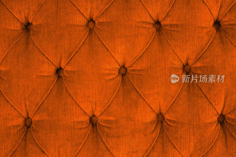 橙色绗缝天鹅绒沙发特写，有软垫纽扣(钻石缝合)/ Rautenheftung